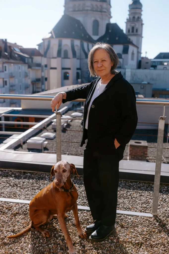 Beate Nowatschka mit Kanzleihund Mila auf der Dachterasse, im Hintergrund der Stift Haug Würzburg